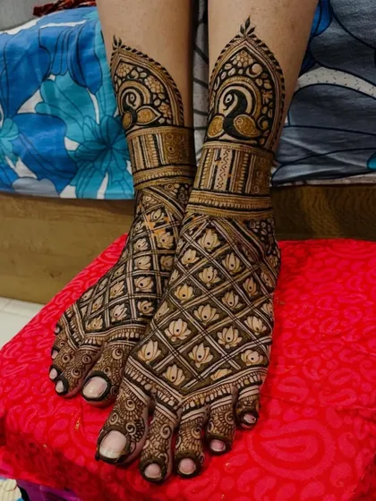 My bridal services include intricate designs for the feet. This particular design features a beautiful jaal pattern with lotus details, topped with elegant peacock figures at the ankle.