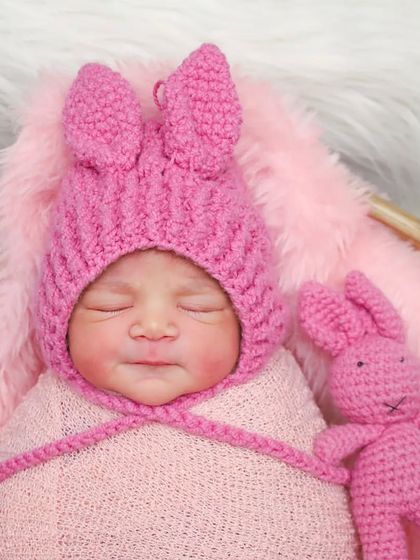 A detailed portrait of a baby in a pink bunny hat. You can see every tiny feature, from her nose to her perfectly shaped lips.