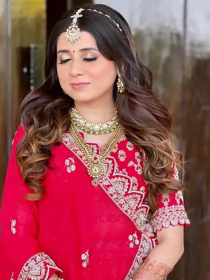 A close-up of the bridal makeup and hair. The soft, golden eyes and pink lips are paired with voluminous curls for a timeless and glamorous look.