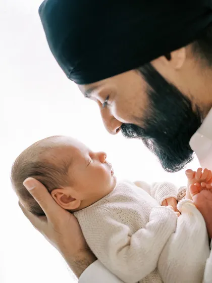A father's gentle gaze at his newborn child. These are the unscripted, heartfelt moments that become the most treasured family memories.