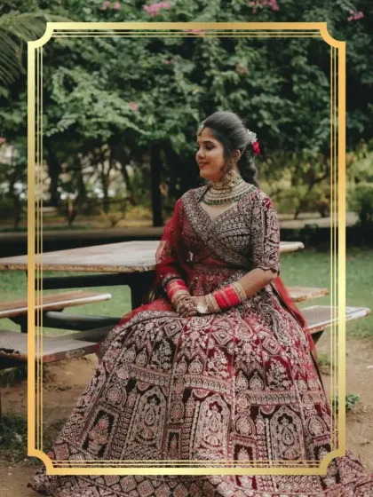 A moment of quiet elegance before the ceremony. This client chose a magnificent maroon bridal lehenga with detailed 'doli' embroidery, adding a beautiful story to her attire.