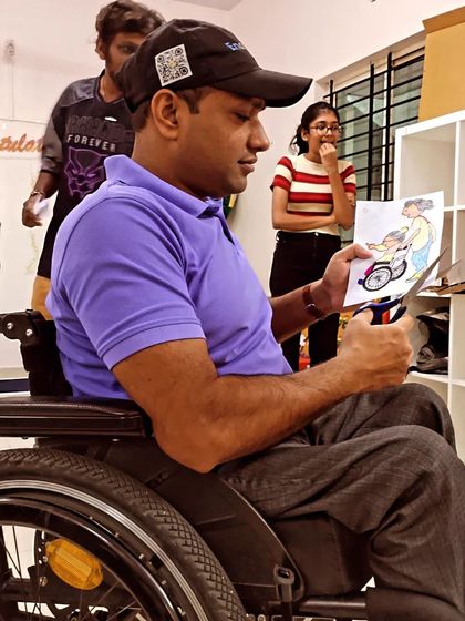 A volunteer in a wheelchair carefully cutting out illustrations. We ensure our volunteering activities and spaces are accessible to everyone who wants to contribute.