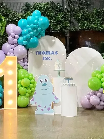 We handle corporate family days and anniversaries with creative, fun themes. This 'Monsters, Inc.' setup for Thomas Inc. included character cutouts, themed balloon colors, and a large light-up number to celebrate their milestone.
