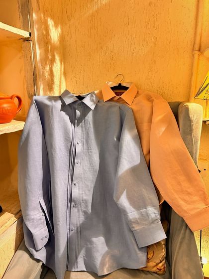 A pair of our custom linen shirts ready for a client. The light blue and peach colors are ideal for building a versatile summer wardrobe.