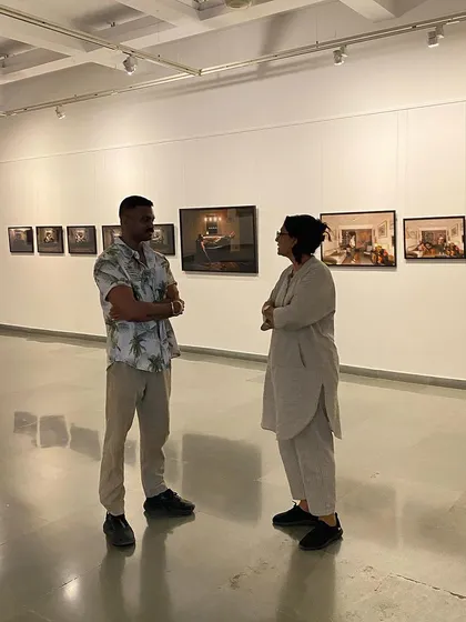 A wide shot of Pushpamala N and Sandeep T K discussing his photographic series.