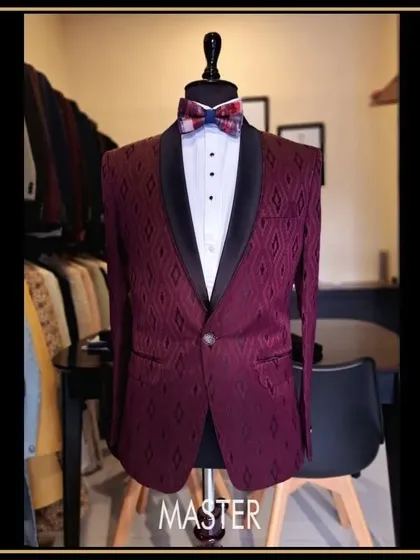 This maroon tuxedo jacket features a unique geometric pattern woven into the fabric. Paired with a black shawl lapel and a patterned bow tie, it's a statement piece for any celebration.