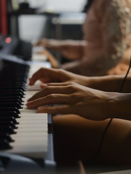 A close up of a student's hands gracefully moving across the piano keys. This shot captures the dedication that goes into every practice session.
