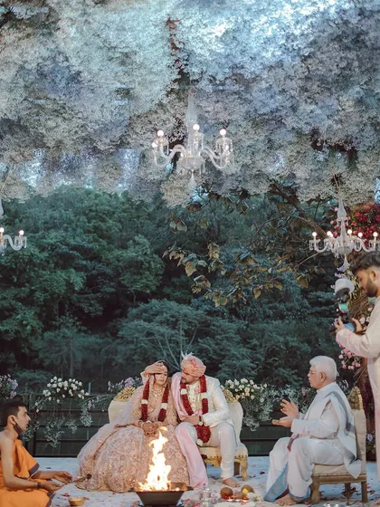 We created an enchanted forest setting for Neha and Tushar's ceremony. A canopy of delicate white flowers and elegant chandeliers hung above them, creating a magical, cloud-like effect that felt both intimate and otherworldly.