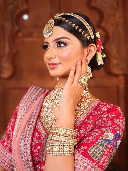 The side profile highlights the beautiful floral bun and the elegant matha patti. We ensure our hairstyles are as flawless and detailed as our makeup.