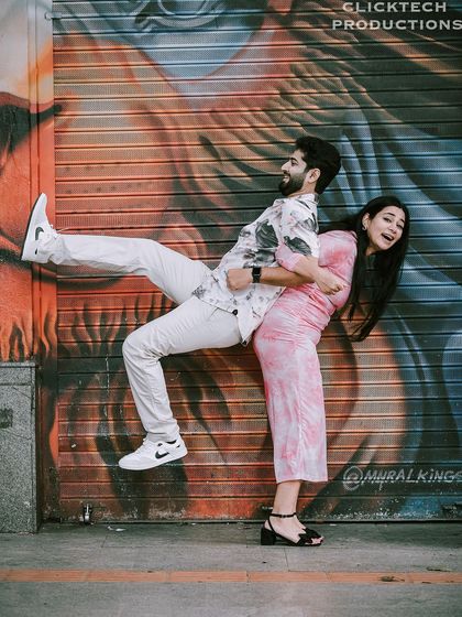 A hilarious and quirky pose against a graffiti wall, showcasing the couple's fun and adventurous personalities.