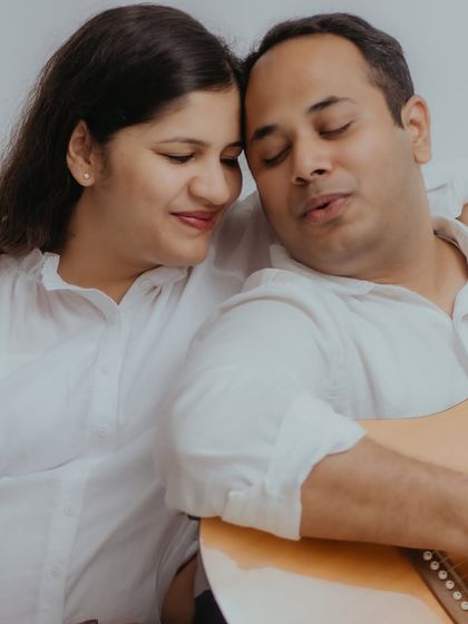 A quiet, intimate close-up as the couple shares a musical moment. This image captures the peaceful and romantic side of their at-home maternity session, focusing on their serene connection.