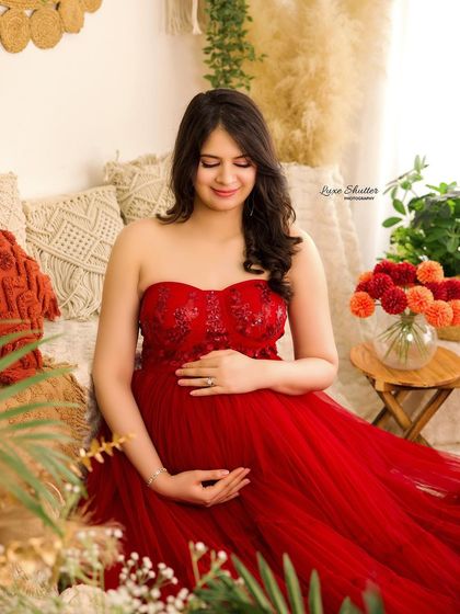 A sweet, candid moment in our boho studio setup. The red gown provides a beautiful pop of color against the neutral, earthy tones of the decor.