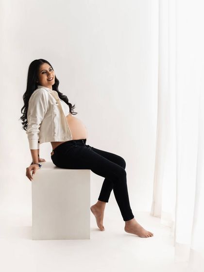 This mom-to-be looks so happy and radiant. Seated in a simple, modern pose, her casual outfit is perfect for a relaxed and comfortable studio session that still feels incredibly chic.