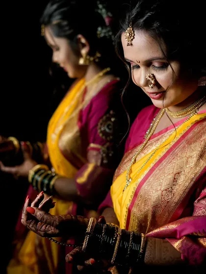 Using reflections to create an artistic portrait, this image shows the bride from multiple angles, highlighting her profile and traditional attire.