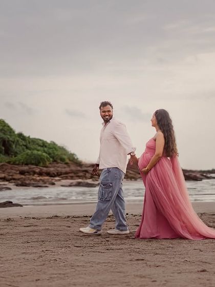 A candid shot of the couple walking on the beach. His backward glance and smile add a lovely, spontaneous feel to this romantic maternity photo.