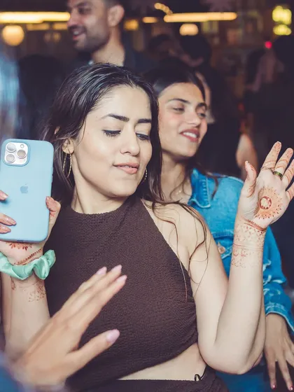 A guest capturing the moment on her phone while dancing.