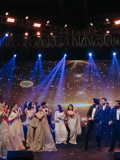 A classic 'ladkivale vs ladkevale' moment. The stage is set for a friendly dance battle, a highlight of any sangeet that we love to choreograph.