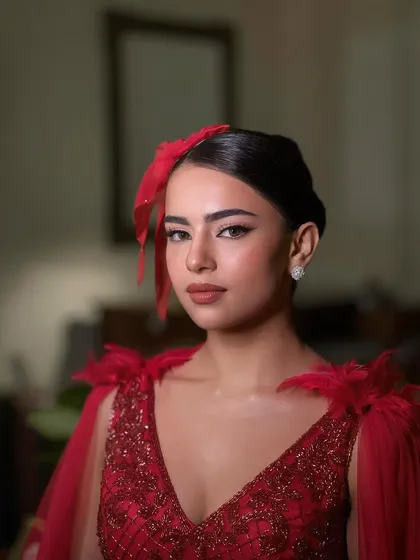 Another angle of this stunning red gown look. The makeup is bold yet clean, with a focus on the dramatic eyes.