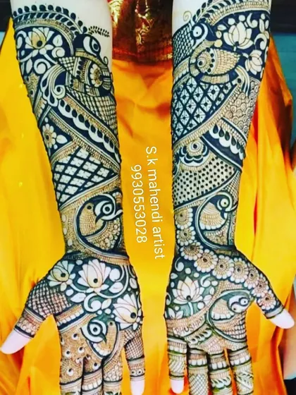 A very dense and flowing design with peacock and lotus motifs. The intricate patterns cover the entire hand and arm, creating a stunning bridal look.