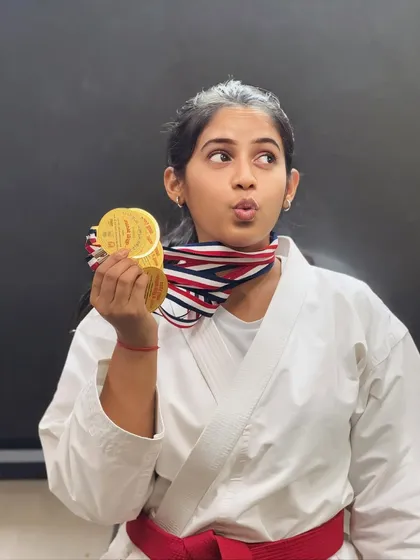 A playful moment with her hard-earned medals. While we are serious about training, we also celebrate the fun and joy the journey brings.