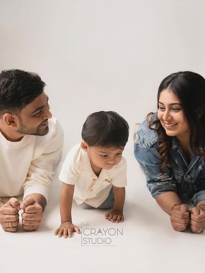 A quiet moment of observation between parents and their child. Lying on the studio floor, the focus is entirely on their interaction and the gentle smiles they share.