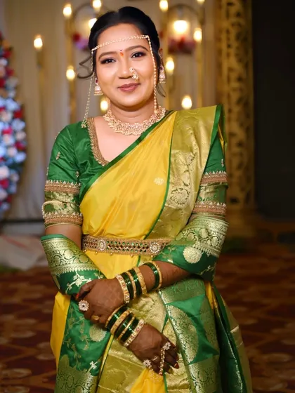 A full-length portrait of the bride in her yellow and green Nauvari. The look is completed with a kamarband (waist belt) and perfectly draped saree.