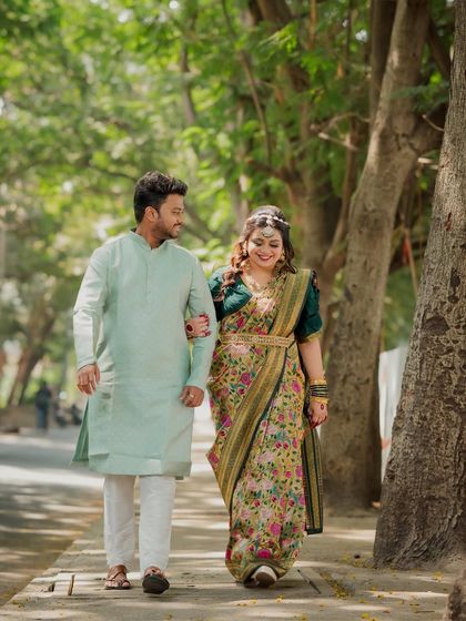 The couple takes a happy stroll together, arm-in-arm. This full-length shot captures their graceful movement and the beauty of their traditional engagement attire.