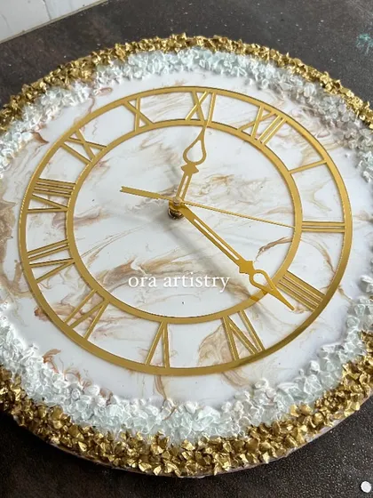 A luxurious resin clock with a gold and white crystal border and a subtle marbled center.