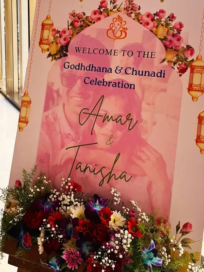 A personalized welcome standee for the Godhana and Chunadi celebration, featuring a photo of the couple and event details.