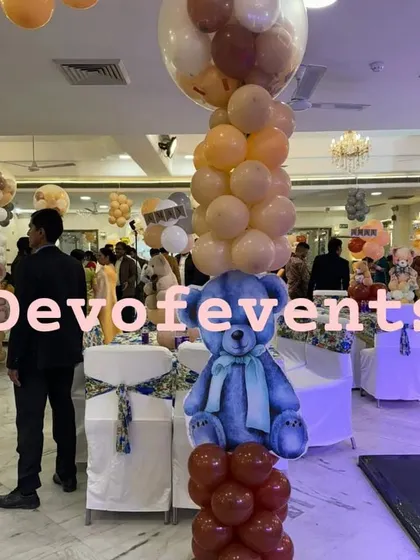 This teddy bear themed centerpiece uses a cutout instead of a stuffed toy, placed on a balloon column. It's a great way to spread the theme throughout a large banquet hall.