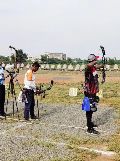 A line of compound bow archers taking aim at the state competition. Each athlete is in their own zone, focused solely on their target.