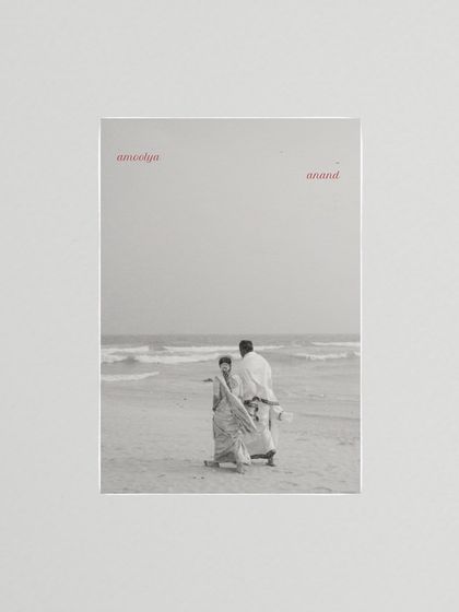 A black and white photo of a couple on the beach, framed with the words 'amoolya anand' (precious joy). This artistic composition turns a simple moment into a poetic statement.