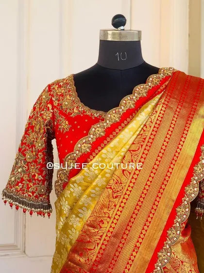 A complete look showing the red bridal blouse paired with a traditional yellow and red Kanchipuram silk saree. The heavy gold embroidery on the blouse perfectly complements the saree's rich border.