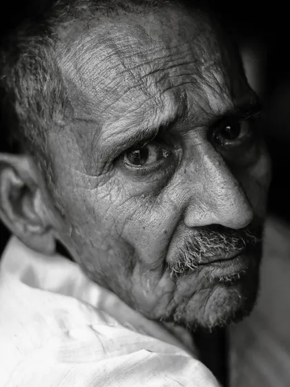 I find that a person's eyes can convey so much without a single word. This close-up, black and white portrait captures the deep emotion and contemplative look of an elderly man, with the shadows emphasizing the lines and character of his face.