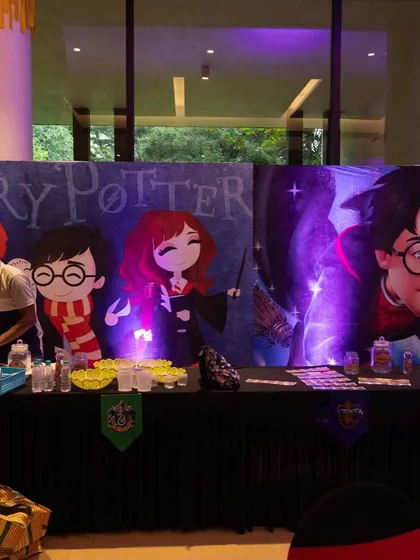 A potions or activity table set against a backdrop of Harry Potter characters, where young wizards can mix their own magical concoctions.