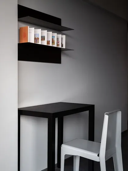 A minimalist study corner featuring a sleek black desk made of bent metal. I design furniture for all types of spaces, and this simple, clean-lined desk is perfect for a small, modern workspace.