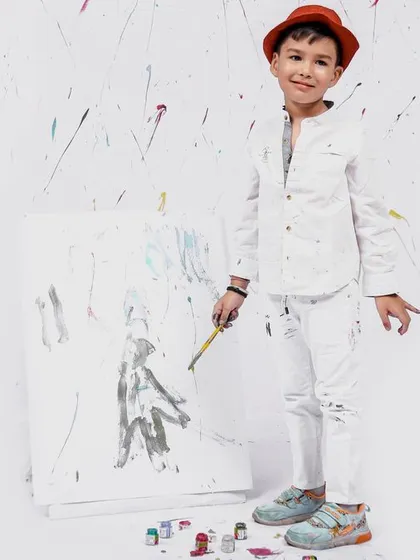 Another dynamic pose from the painter-themed shoot, capturing the fun and energy of the session as the little boy interacts with his artwork.