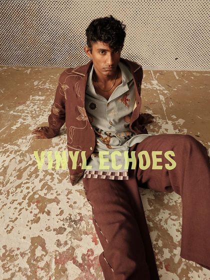 A seated portrait from the Cord "Vinyl Echoes" shoot, capturing a relaxed yet stylish mood.