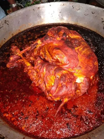 A whole chicken roasting in a rich, red masala. This is a centerpiece dish for any special occasion.