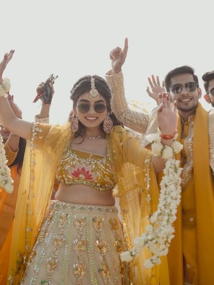 A happy bride celebrating her Haldi in our yellow and cream lehenga with lotus motifs. This outfit is designed to be bright, cheerful, and perfect for the occasion.