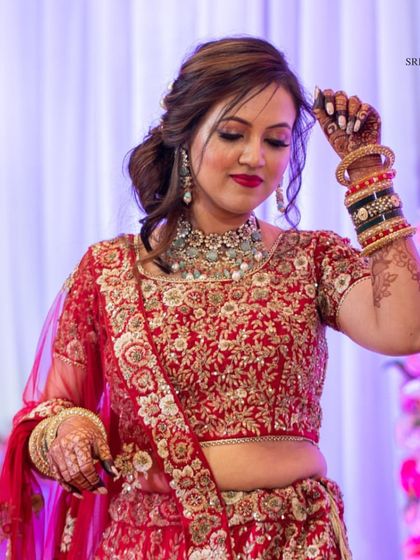 A candid moment of our bride looking radiant in a red lehenga. She chose a beautiful choker set with matching earrings and bangles to complete her traditional wedding attire.