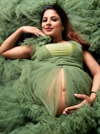 An artistic overhead shot that turns the gown into a beautiful nest. This perspective offers a unique and stunning way to photograph the baby bump.