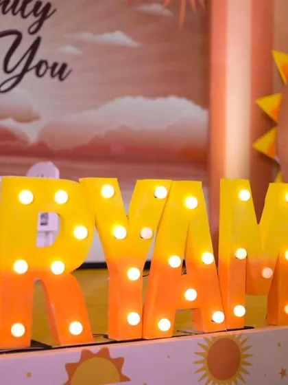 Personalization is key. These custom marquee letters, spelling out the baby's name in warm, glowing lights, add a spectacular and personal touch to any stage or photo corner, making the event uniquely yours.