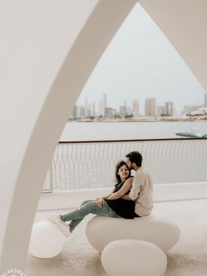 A romantic pose framed within a modern architectural arch, with the Dubai skyline in the distance.
