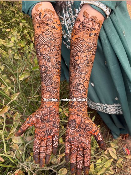 A complete bridal mehendi design for both arms, showcasing the rich texture and depth created by mixing fine lines with bold, filled elements.
