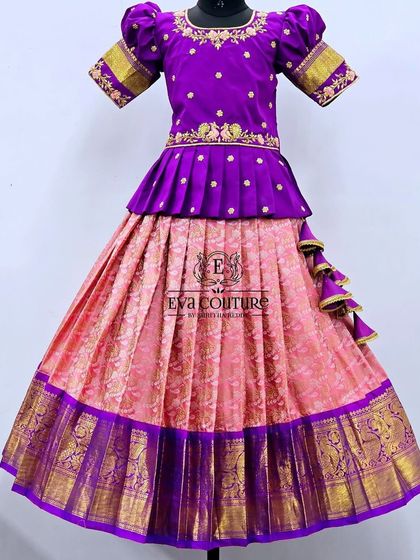 A beautiful purple and pink Kanchi Pattu lehenga. The blouse has a pleated peplum and peacock embroidery.