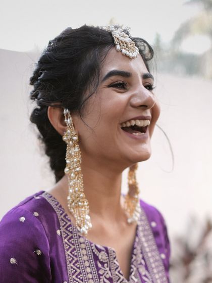 The joy on a client's face says it all. Here she is, laughing and enjoying her Mehendi, wearing her custom D'oro earrings and bindiya set that we designed together.