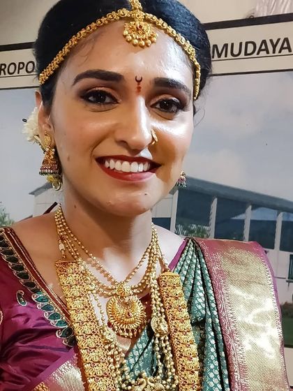 Pooja's radiant smile says it all. Her muhurtham makeup was kept fresh and glowing, with a warm red lip to complement her traditional attire.