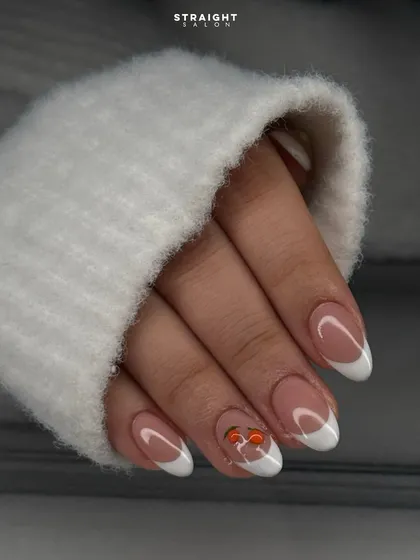 A classic French manicure with a playful, hand-painted cherry accent. This shows how you can add a touch of personality to a timeless look.