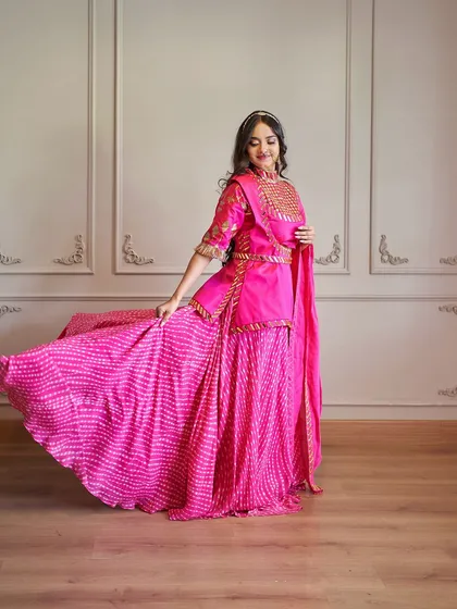 My collection isn't just about gowns. For your traditional functions or a vibrant pre-wedding theme, this hot pink Rajputani-style outfit is a stunning choice. It features beautiful mirror work and a flowing leheriya skirt that’s perfect for twirling.
